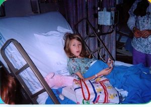 Blythe is sitting in a hospital bed as a child.